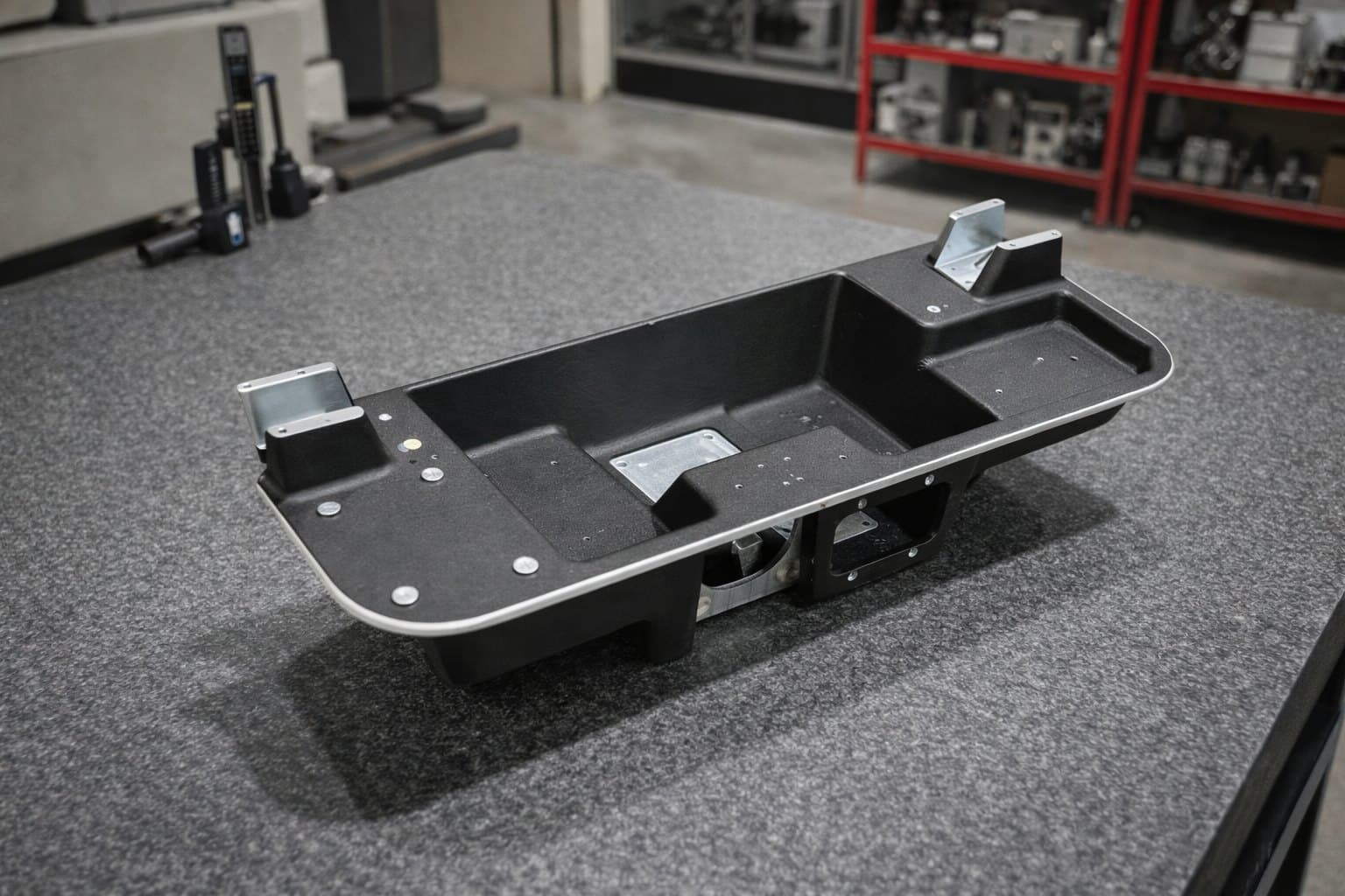 Medical surgery table base casting on a shop floor.